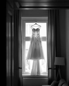 a wedding dress is hanging in a window at EL GUSTO HOMES Town in Sopron