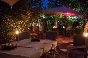 a table and an umbrella in a garden at night at B&B Pura Vista in Zandhoven