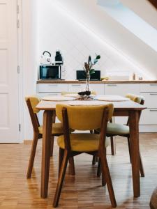 uma mesa de jantar com cadeiras amarelas numa cozinha em Vila Na Landeku em Ostrava