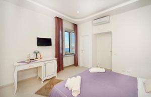 a white room with a bed and a desk and a sink at Terra Murata Boutique b&b in Procida