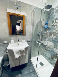 La salle de bains est pourvue d'un lavabo et d'une douche. dans l'établissement Appartamento Bandiera Blu, à Sirolo