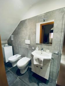 La salle de bains est pourvue d'un lavabo, de toilettes et d'un miroir. dans l'établissement Appartamento Bandiera Blu, à Sirolo