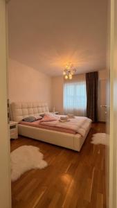 - une chambre avec un grand lit et une fenêtre dans l'établissement apartman nejra, à Tuzla