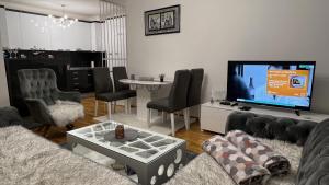 a living room with a couch and a flat screen tv at apartman nejra in Tuzla
