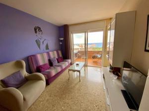 a living room with a couch and a tv at Apartamento Fanals in Lloret de Mar