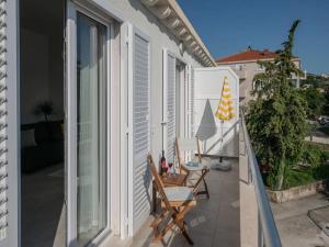 einen Balkon mit 2 Stühlen und einem Sonnenschirm in der Unterkunft Apartment Dolce in Cavtat