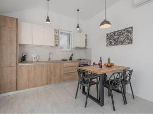 eine Küche mit einem Holztisch und Stühlen darin in der Unterkunft Apartment Dolce in Cavtat