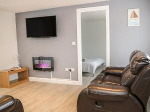 a living room with a couch and a flat screen tv at Bankswood in Dumfries