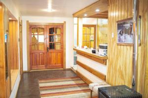een kamer met houten wanden en een keuken met een aanrecht bij Roble Austral Hostal in Coihaique