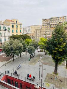 um autocarro vermelho numa cidade com edifícios em B&B Conte Cavour em Nápoles