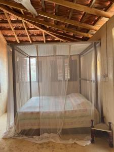 
a bed in a room with a wooden floor at Subira House in Lamu

