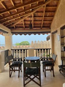 una sala da pranzo con tavolo e sedie su un balcone di Subira House a Lamu