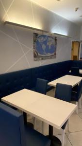 a classroom with white tables and blue chairs at Hotel Holiday in Bologna