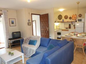 a living room with a blue couch and a kitchen at Holiday Home Les Hauts de Grimmal by Interhome in Salles-dʼAude