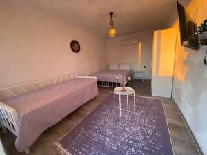 1 Schlafzimmer mit 2 Betten, einem Tisch und einem TV in der Unterkunft The Stone Castle Boutique Hotel in Ağaçlı
