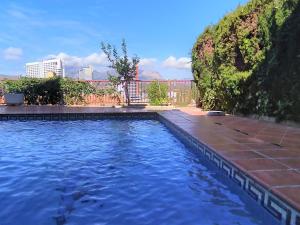 a swimming pool with blue water in front of a building at Holiday Home Mar y Montaña by Interhome in Benidorm