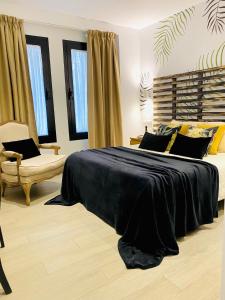 a bedroom with a large black bed and a couch at Hostal Alisol Boutique San Pedro in Marbella