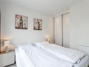 una camera bianca con un grande letto e due quadri sul muro di Holiday Home Green Resort Mooi Bemelen-1 by Interhome a Bemelen
