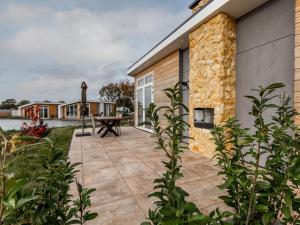 um pátio com uma mesa de piquenique ao lado de um edifício em Holiday Home Green Resort Mooi Bemelen by Interhome em Bemelen