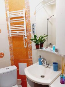 a bathroom with a toilet and a sink and a mirror at Квартира на Плазе in Aktobe