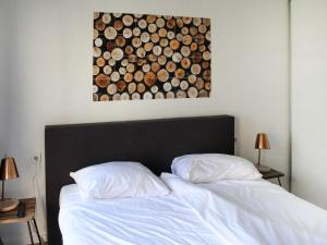 een bed met twee kussens en een schilderij aan de muur bij Holiday Home Ravenbosch- 5p by Interhome in Bemelen