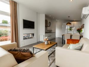 un soggiorno con due divani bianchi e un tavolo di Holiday Home Green Resort Mooi Bemelen by Interhome a Bemelen