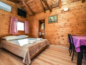 - une chambre avec un lit dans une cabane en bois dans l'établissement Holiday Home Palma-5 by Interhome, à Anić