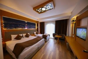 Habitación de hotel con 2 camas y TV de pantalla plana. en Ruby Royal, en Estambul