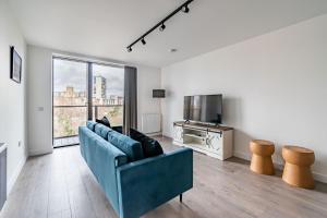 sala de estar con sofá azul y ventana grande en amazing apartments - Great Junction St - by Water of Leith, en Edimburgo
