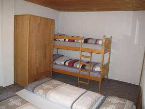 GarzにあるHoliday Home Kaiser by Interhomeの二段ベッド2台と木製キャビネットが備わる客室です。
