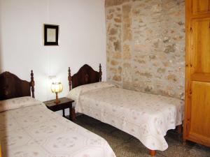 カラ・サンタニーにあるHoliday Home Sa Caseta by Interhomeの石壁のベッドルーム1室(ベッド2台付)