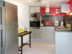 eine Küche mit einem Kühlschrank aus Edelstahl und einem Tisch in der Unterkunft Holiday Home La Chevalerie - SUB102 by Interhome in Sourdeval-les-Bois
