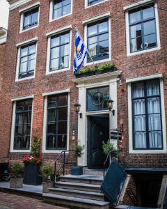 ein rotes Backsteingebäude mit einer Flagge darauf in der Unterkunft B&B 't Poorthuys in Middelburg