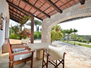 a patio with a table and chairs and a stone wall at Holiday Home Latin - RCA400 by Interhome in Barban