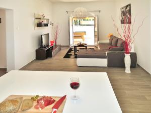 a living room with a table with a glass of wine at Holiday Home Dordana - LBN440 by Interhome in Labin