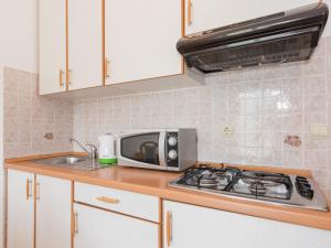 a kitchen with a microwave and a stove top oven at Apartment Adria - RAC171 by Interhome in Rabac