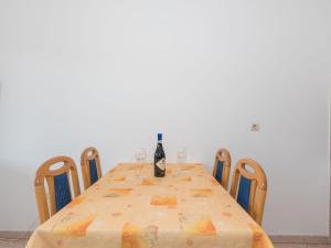 a dining room table with a bottle of wine on it at Apartment Adria - RAC171 by Interhome in Rabac