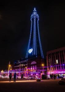 a tower lit up at night with a clock on it at Bel Reve Hotel in Blackpool