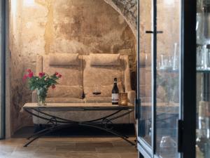 einen Tisch mit einer Flasche Wein und einer Vase Blumen in der Unterkunft Apartment Mulino by Interhome in Montegrazie