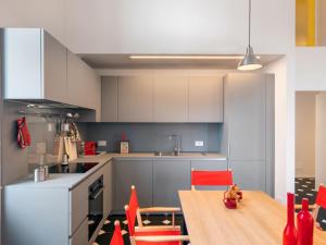 a kitchen with a wooden table and red chairs at Apartment Terrazza sul molo by Interhome in Alassio