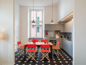 a kitchen with a table and red chairs at Apartment Terrazza sul molo by Interhome in Alassio