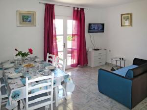 uma sala de estar com uma mesa e um sofá em Holiday Home Maslina - TGR616 by Interhome em Voluja