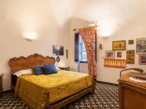 a bedroom with a bed with a yellow bedspread at Holiday Home Angela - DOL100 by Interhome in Dolcedo