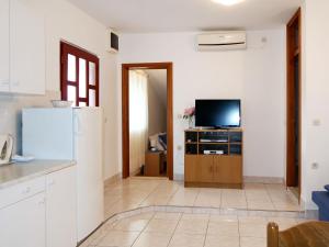 a kitchen with a refrigerator and a tv at Apartment Haus Peric - KOR201 by Interhome in Prigradica