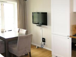 a room with a table and a television on a wall at Apartment Havsdalshovda - HLD101 by Interhome in Geilo