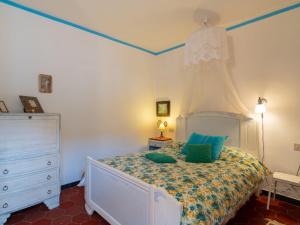 a bedroom with a bed with green pillows and a dresser at Apartment Casa del Cavaliere by Interhome in Dolcedo