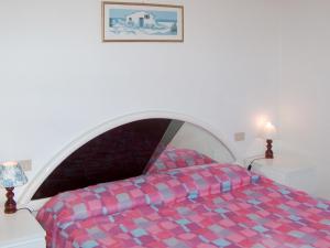 MadernoにあるHoliday Home Turelli-2 by Interhomeのベッドルーム1室(赤と青のベッドカバー付)