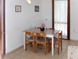 MadernoにあるHoliday Home Turelli-2 by Interhomeのダイニングルームテーブル(椅子、花瓶付)