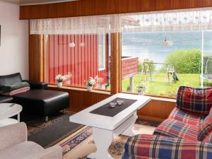 sala de estar con sofá, mesa y ventana en Apartment Mjellhaugen - FJS221 by Interhome, en Naustdal i Sunnfjord
