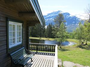 eine Bank auf der Veranda eines Hauses mit Bergblick in der Unterkunft Chalet Fjellro - FJS103 by Interhome in Holsen
